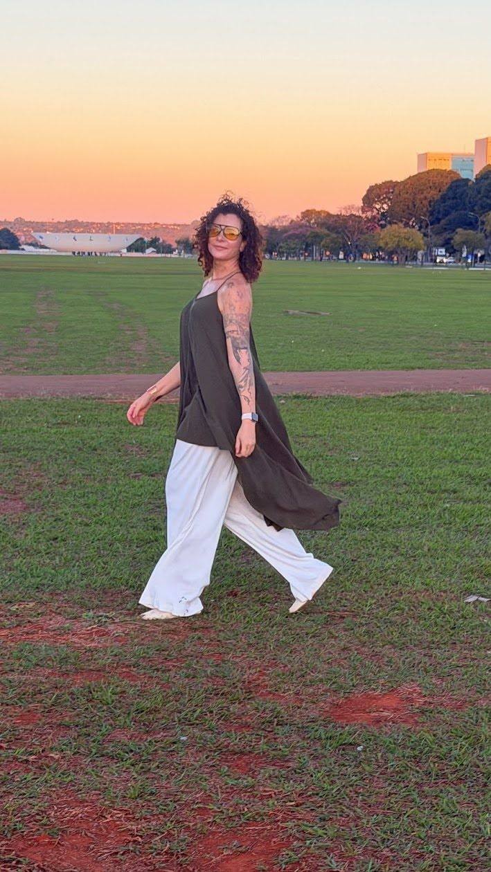 Jaya caminhando no gramado ao entardecer